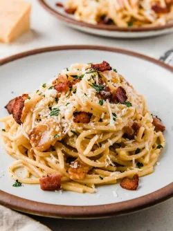 carbonara-on-a-plate-sprinkled-with-cheese-and-parsley.webp