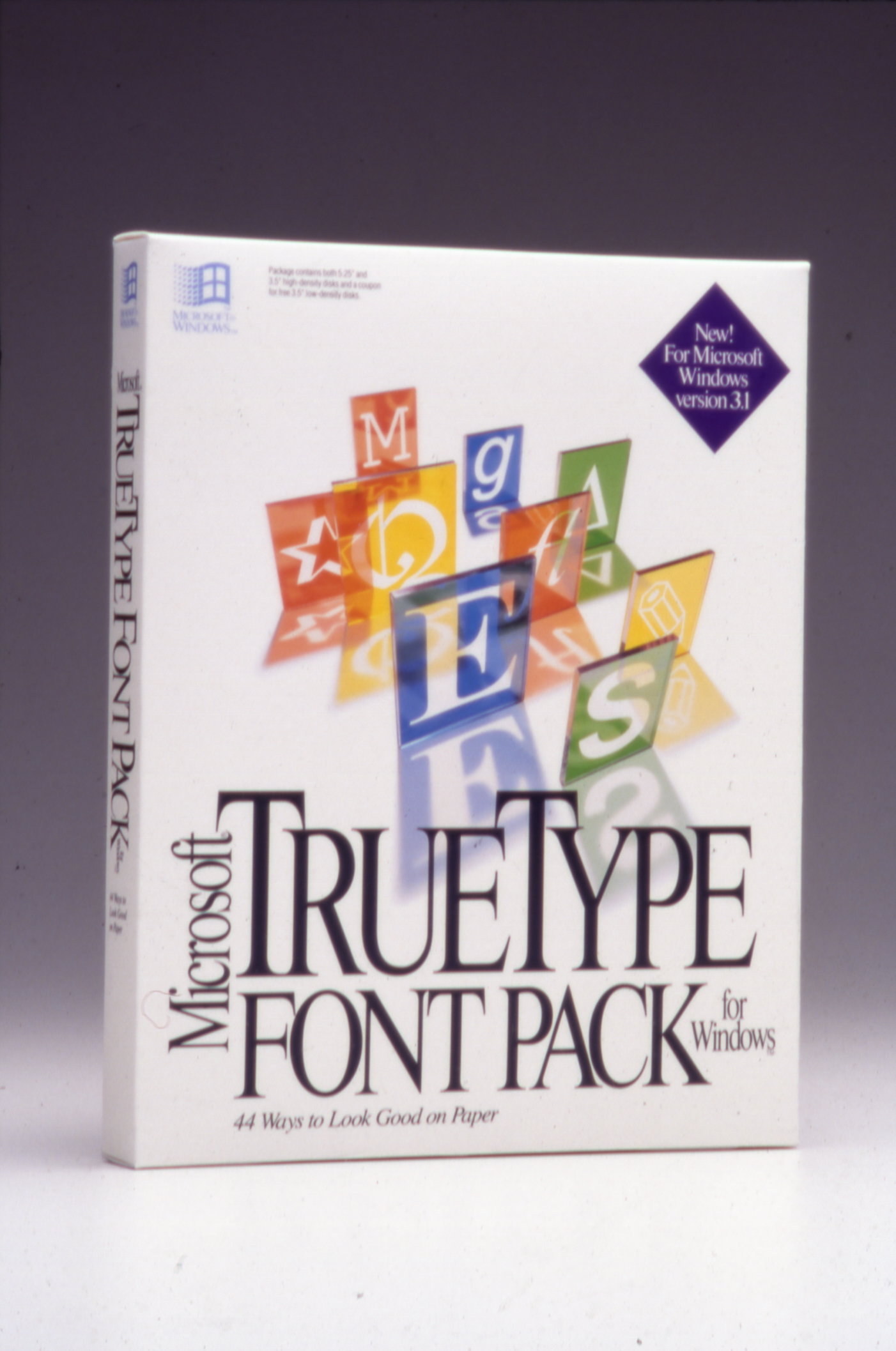 A white software box for Microsoft TrueType Font Pack for Windows featuring colorful 3D letter blocks and large, elegant black text on the front. A purple badge states, New! For Microsoft Windows version 3.1.