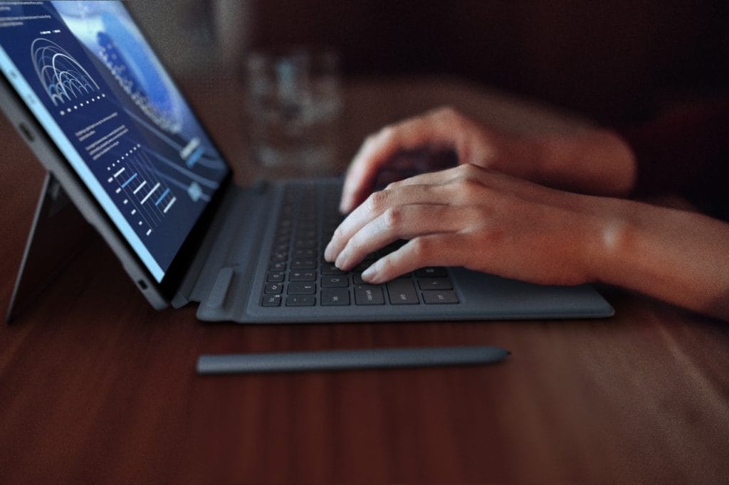 Someone working on a Dell Latitude 7350 as seen close-up and in profile