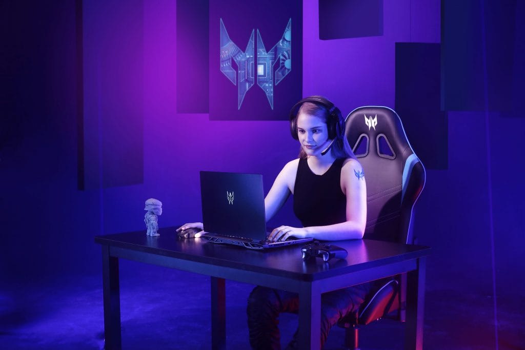 Woman sitting in a purple lit room in front of Predator Helios 300